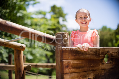 Girl standing and smiling on playground ride in park