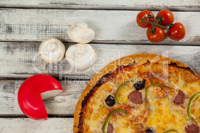 Italian pizza on wooden plank with vegetables and cheese