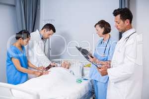 Doctors examining patient in ward