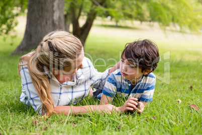 Happy mother and son lying in park