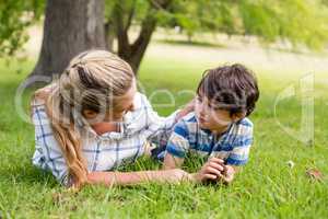 Happy mother and son lying in park