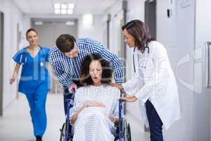 Doctor and man comforting pregnant woman in corridor