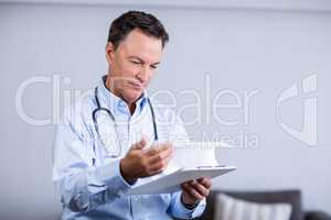 Male doctor reading reports