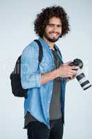 Happy photographer holding a camera in the studio