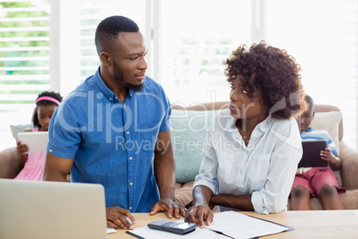 Couple sitting at table and calculating bills