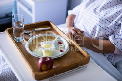 Tray with apple and medicine kept on front of patient