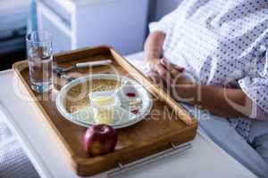 Tray with apple and medicine kept on front of patient