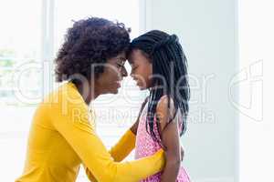 Mother and daughter embracing face to face