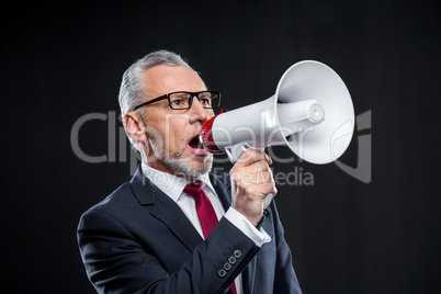 Mature businessman with loudspeaker