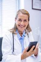 Portrait of female doctor using mobile phone