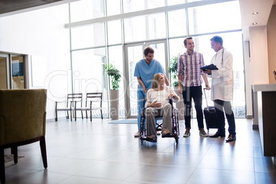 Male doctor talking to pregnant woman in wheelchair