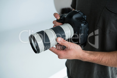 Mid section of male photographer standing in studio