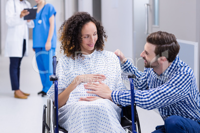 Man comforting pregnant woman in corridor