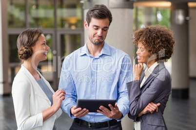 Business executives discussing over digital tablet