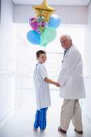 Doctor walking with patient in hospital corridor