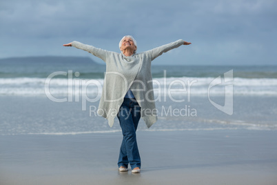 Senior woman doing stretching exercise on the beach