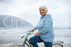 Senior woman riding bicycle on the beach