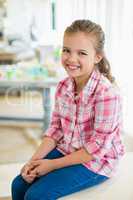 Smiling cute girl sitting on table