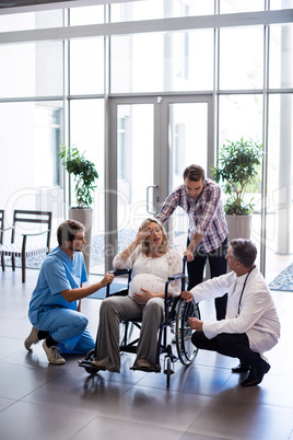 Male doctor talking to pregnant woman in wheelchair