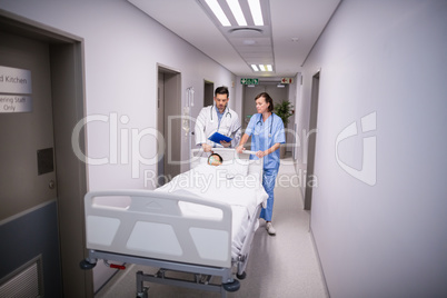 Doctors pushing emergency stretcher bed in corridor