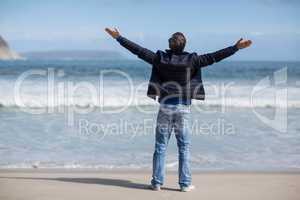 Mature man with arms outstretched standing on the beach