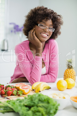 Beautiful woman leaning with hand on face in kitchen