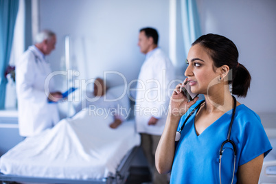 Female doctor talking on a mobile phone in the ward