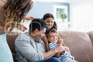 Parents and kids having fun in living room
