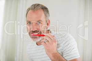 Portrait of man brushing teeth in bathroom