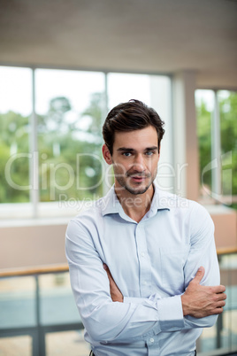 Male business executive with arms crossed at conference center