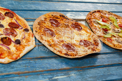 Various delicious italian pizza served on wooden plank