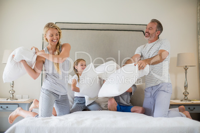 Cute family having a pillow fight in bedroom