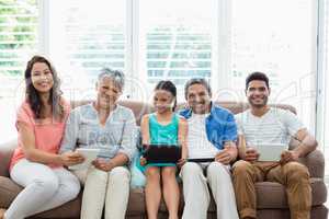 Multi-generation family using digital tablet in living room at home
