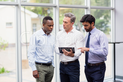 Business executives discussing over digital tablet