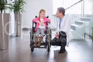Smiling doctor talking to disable girl