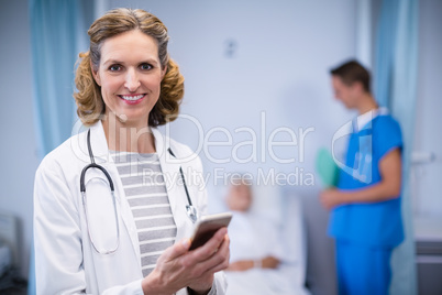 Portrait of smiling doctor using mobile phone