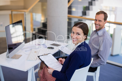 Businesswoman working at desk with colleague