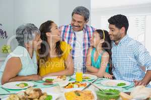 Happy multi generation family having meal on table at home