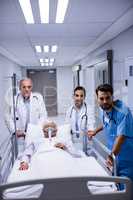 Doctor and nurse pushing emergency stretcher bed in corridor