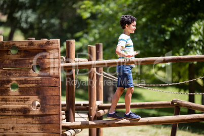 Boy walking on a playground ride in park