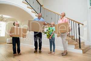 Parents and kids holding cardboard boxes in living room at home