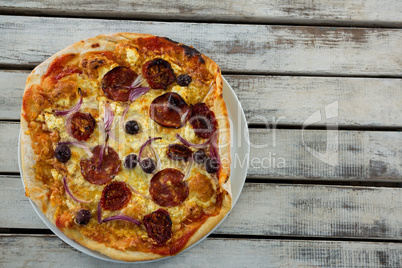 Italian pizza in a plate on a wooden plank