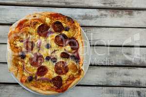 Italian pizza in a plate on a wooden plank