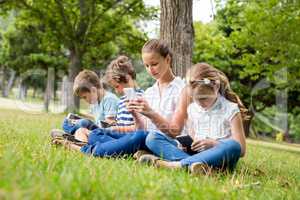 Kids using mobile phone in park