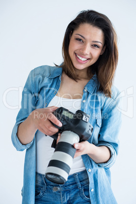 Happy female photographer standing in studio