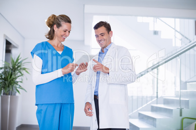 Nurse and doctor discussing over digital tablet