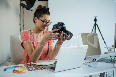 Female photographer reviewing captured photos in her digital camera