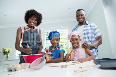 Parents and kids preparing food in kitchen at home