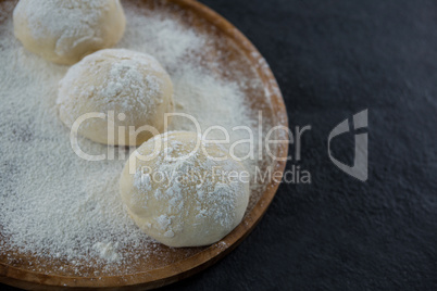 Pizza dough ball on a wooden tray