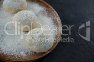 Pizza dough ball on a wooden tray